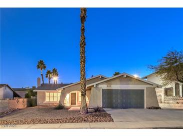 Single-story home with gray garage door and palm trees at 5117 Dancer Way, Las Vegas, NV 89107