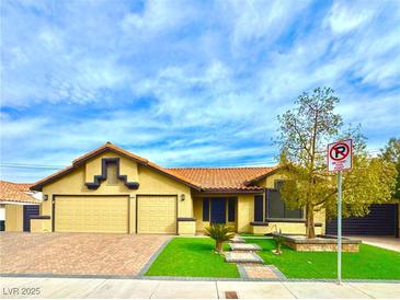 House exterior featuring a two-car garage and well-manicured lawn at 7874 Clearwood Ave, Las Vegas, NV 89123