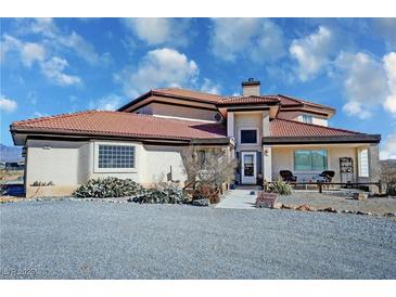 Single-story home with red tile roof, large windows, and landscaped yard at 3821 S Tumbleweed Ave, Pahrump, NV 89048