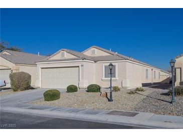 Single-story house with a two-car garage and desert landscaping at 5916 Naperville St, Las Vegas, NV 89130
