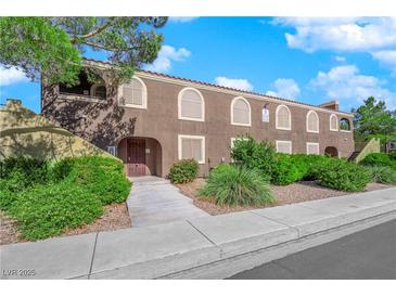 Exterior view of a light brown building with landscaping and walkway at 7950 W Flamingo Rd # 1041, Las Vegas, NV 89147