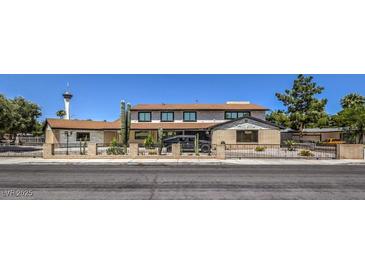 Two-story home features a low brick fence and desert landscaping in a classic suburban neighborhood at 1420 S 8Th St, Las Vegas, NV 89104