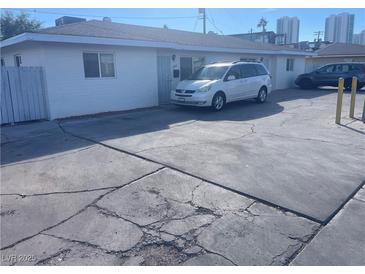 Front view of a single story home with a spacious driveway and parking area at 1905 Weldon Pl, Las Vegas, NV 89104