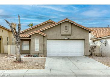 One-story house with a white garage door and desert landscaping at 5055 Jacarilla Ln, North Las Vegas, NV 89031