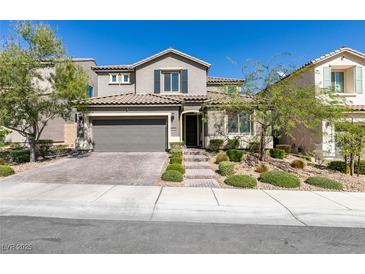 Two-story house with gray siding, a three-car garage, and well-manicured landscaping at 9994 Celestial Cliffs Ave, Las Vegas, NV 89166