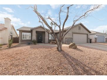 Single-story house with a two-car garage and desert landscaping at 1009 Beaver Crest Ter, Henderson, NV 89015