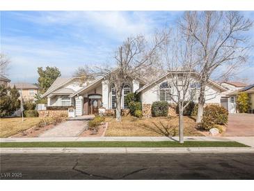 Single-story house with a large front yard, stone accents, and a three-car garage at 1010 Legacy Dr, Boulder City, NV 89005