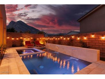 Stunning backyard oasis featuring a sparkling pool, spa, and outdoor lighting at 10936 White Alder Pl, Las Vegas, NV 89138