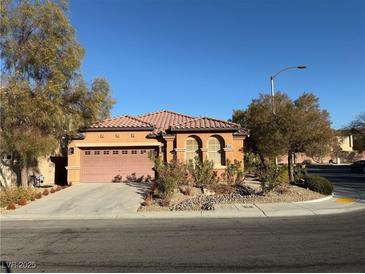 Single-story home with a terracotta tile roof and a two-car garage at 11106 Cherokee Landing St, Las Vegas, NV 89179