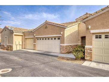 Tan colored stucco home with attached garage and landscaping at 237 Garrett Ln # 2, Boulder City, NV 89005