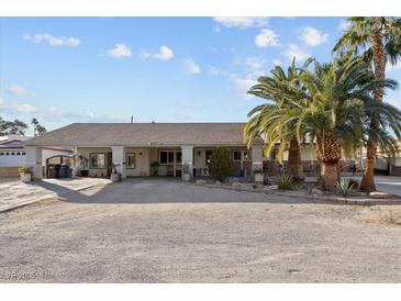 Single-story home with covered porch, palm trees, and a large driveway at 4365 Topaz St, Las Vegas, NV 89121