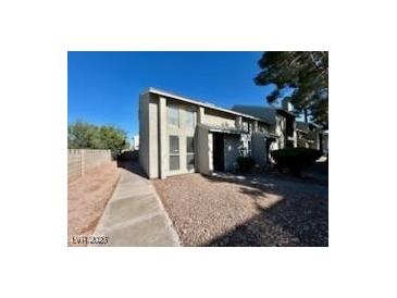 Exterior view of a light-colored townhouse with a walkway and small yard at 569 Sellers Pl # 569, Henderson, NV 89011