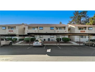 Exterior view of apartment building with carport and parking spaces at 7300 Pirates Cove Rd # 2013, Las Vegas, NV 89145