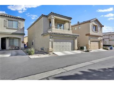 Two-story home featuring a two car garage, covered porch, and small balcony at 7868 Running Doe Ct, Las Vegas, NV 89149