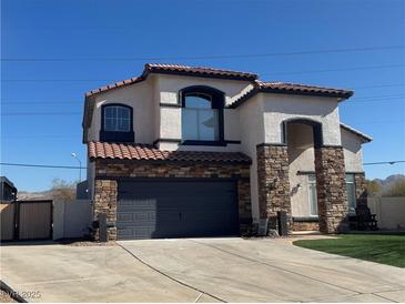 Two-story house with stone accents, a two-car garage, and a well-manicured lawn at 1138 Gainesborough Ct, Henderson, NV 89015