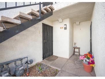 Condo entrance featuring secure door, concrete stairs and walkway with rock landscaping at 1701 E Katie Ave # 65, Las Vegas, NV 89119