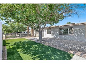 Charming single story home with a spacious front yard, artificial turf, and mature shade tree at 209 N 21St St, Las Vegas, NV 89101