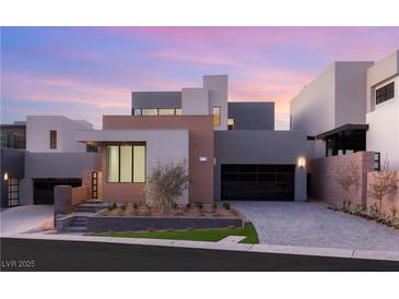 Contemporary home featuring a manicured lawn, geometric design, and a two-car garage at 506 Overlook Rim Dr, Henderson, NV 89012