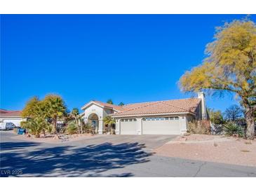 Single-story house with a three-car garage and desert landscaping at 6185 N Conquistador St, Las Vegas, NV 89149