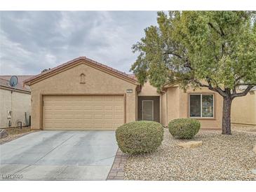 Single-story house with tan exterior, two-car garage, and mature landscaping at 7517 Lintwhite St, North Las Vegas, NV 89084