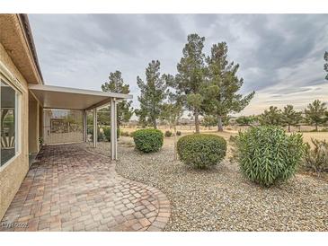 Charming patio area with brick pavers, landscaping, and views of the golf course at 7517 Lintwhite St, North Las Vegas, NV 89084