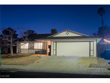 Charming single-story home with a two-car garage and gravel landscaping at dusk at 7905 Aplin Ave, Las Vegas, NV 89145