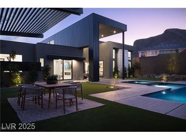Modern backyard featuring a pool, spa, outdoor dining area, and sleek architectural design at 4377 Cameron Brook Ct, Las Vegas, NV 89129