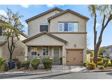 Tan two-story house with a two-car garage and well-manicured landscaping at 6748 Wormwood Ln, Las Vegas, NV 89148