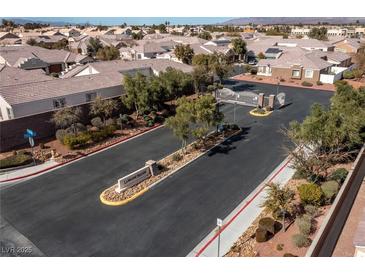 Community entrance featuring manicured landscaping, decorative signage, and a secure gate, with well-maintained homes visible beyond at 1069 Appleblossom Time Ave, North Las Vegas, NV 89031