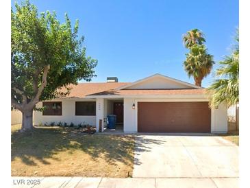 Single story home with brown garage door and landscaped yard at 4457 Rita Dr, Las Vegas, NV 89121