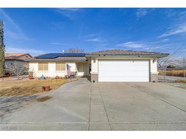 Charming single-story home featuring a two car garage and a well-manicured lawn at 2121 Upland Ave, Pahrump, NV 89048