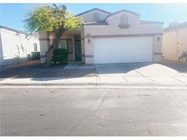 Single-story house with a white garage door and landscaping at 2132 Fred Brown Dr, Las Vegas, NV 89106