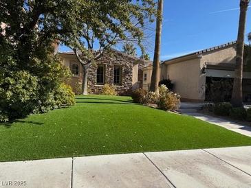 Single-story home with stone accents and a manicured lawn at 2794 Evening Rock St, Las Vegas, NV 89135