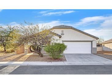 Single-story house with a white garage door and desert landscaping at 5725 Copper Sun Ct, North Las Vegas, NV 89031