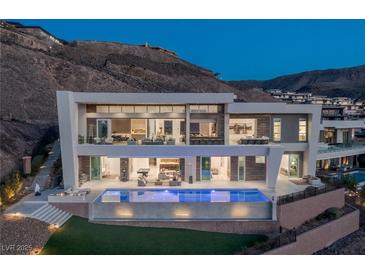 Modern home boasts a beautiful pool and outdoor entertaining spaces, perfect for enjoying the hillside views at 631 Cityview Ridge Dr, Henderson, NV 89012