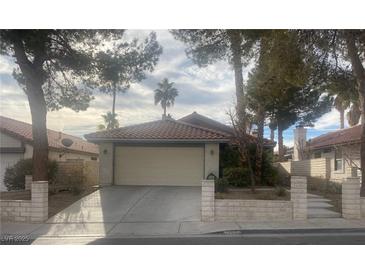 Single-story home with attached garage and landscaped yard at 705 Thousand Oaks Dr, Las Vegas, NV 89123