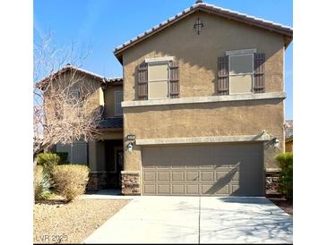 Two-story house with beige exterior and brown shutters at , Henderson, NV 89011