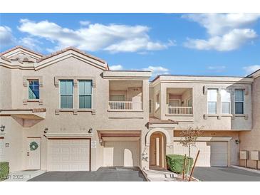 Charming multi-level townhome with stucco exterior, private balconies, and attached garages under a blue sky at 10550 W Alexander Rd # 1007, Las Vegas, NV 89129