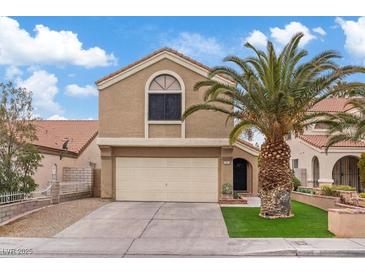 Two-story house with a beige exterior, attached garage, and palm tree landscaping at 3321 Mariner Bay St, Las Vegas, NV 89117