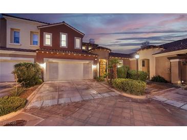 Exterior of home with two-car garage, landscaping, and sunset view at 38 Strada Principale, Henderson, NV 89011