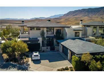 Stunning desert home featuring modern design, lush landscaping, and a spacious driveway at 4929 Summit Overlook Dr, Las Vegas, NV 89135