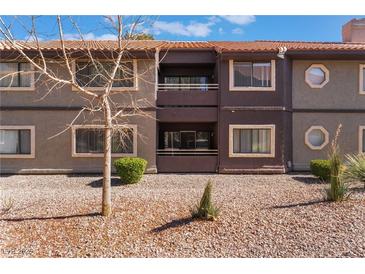 Two-story condo building features balconies, neutral colors, and desert landscaping in a well-maintained community at 5046 S Rainbow Blvd # 103, Las Vegas, NV 89118