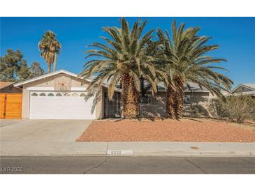 Single-story house with a white garage door and palm trees in the front yard at 6232 Lanning Ln, Las Vegas, NV 89108