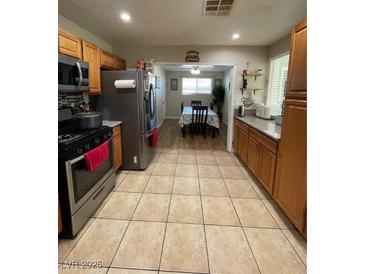 Well-lit kitchen featuring stainless steel appliances and tile flooring throughout with eating area at 1737 W Nelson Ave, North Las Vegas, NV 89032