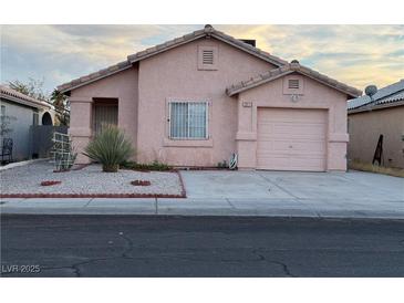 One-story house with pink stucco exterior, attached garage, and small front yard at 2017 Emerald Green Ave, Las Vegas, NV 89106