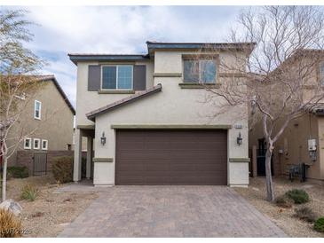 Beige two-story home featuring a brown two-car garage and a brick driveway at 2240 Sky Island Dr, Henderson, NV 89002