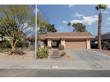 Tan house with a two-car garage and nicely landscaped front yard at 3126 Cabachon Ave, Las Vegas, NV 89121