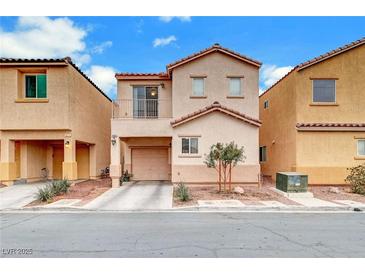 Two story house with tan exterior,balcony, attached garage, and landscaping at 4064 Emerald Wood St, Las Vegas, NV 89115