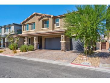 Two-story house with gray siding, stone accents, and a two-car garage at 4128 Fossatello Ave, North Las Vegas, NV 89084