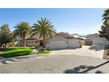Charming single-story home with mature palm trees, three-car garage, and well-maintained landscaping at 5625 W Agate Ave, Las Vegas, NV 89139